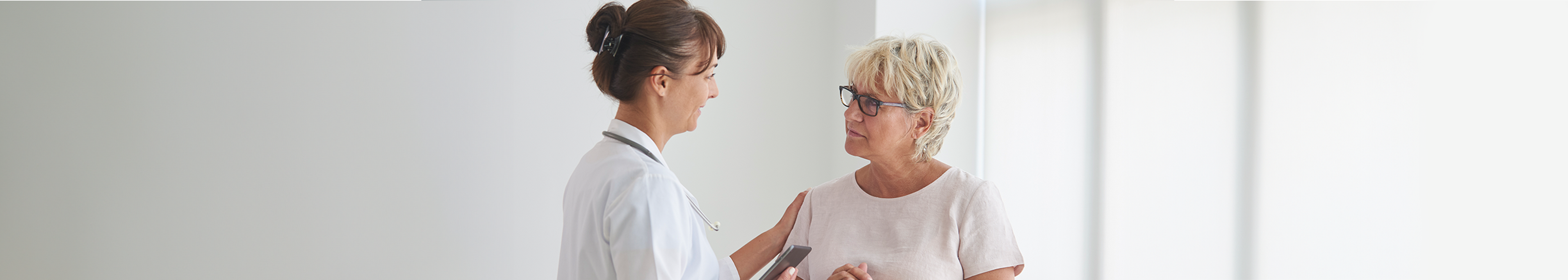 Female doctor talking to a female patient in her 50s about her mammogram